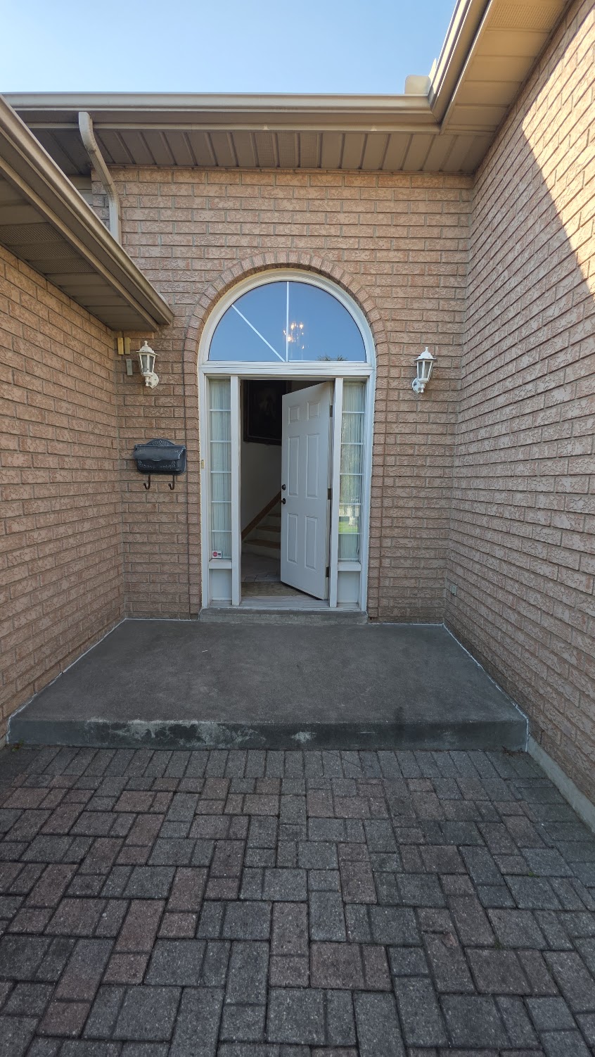 Front entrance — one step up from the paved driveway to the covered porch area